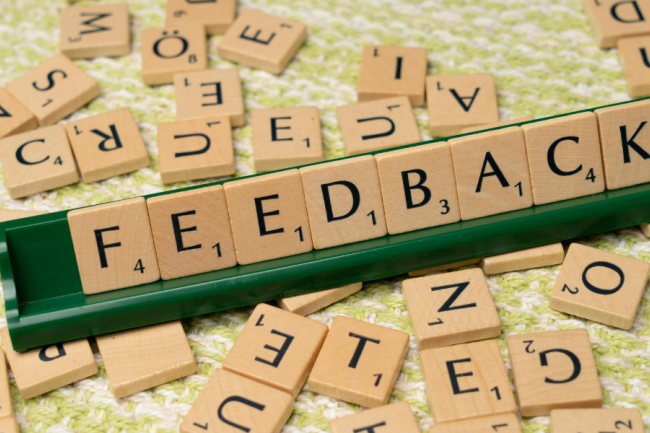 Decorative image of a Scrabble crib with letters spelling "feedback"