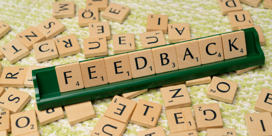 Decorative image of a Scrabble crib with letters spelling "feedback"